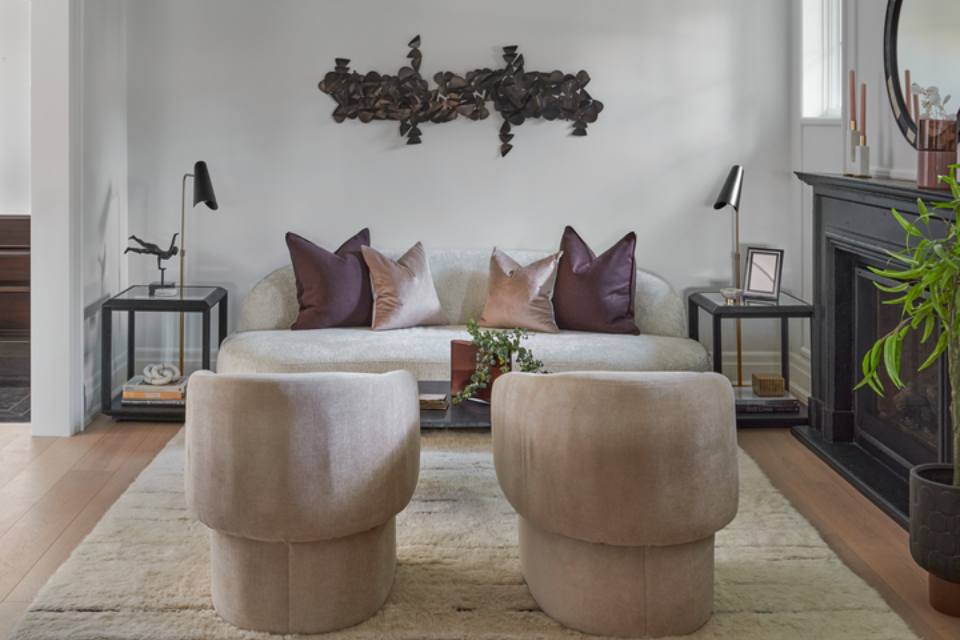 living room with wood floors and accent rug white couch and blush accent chairs